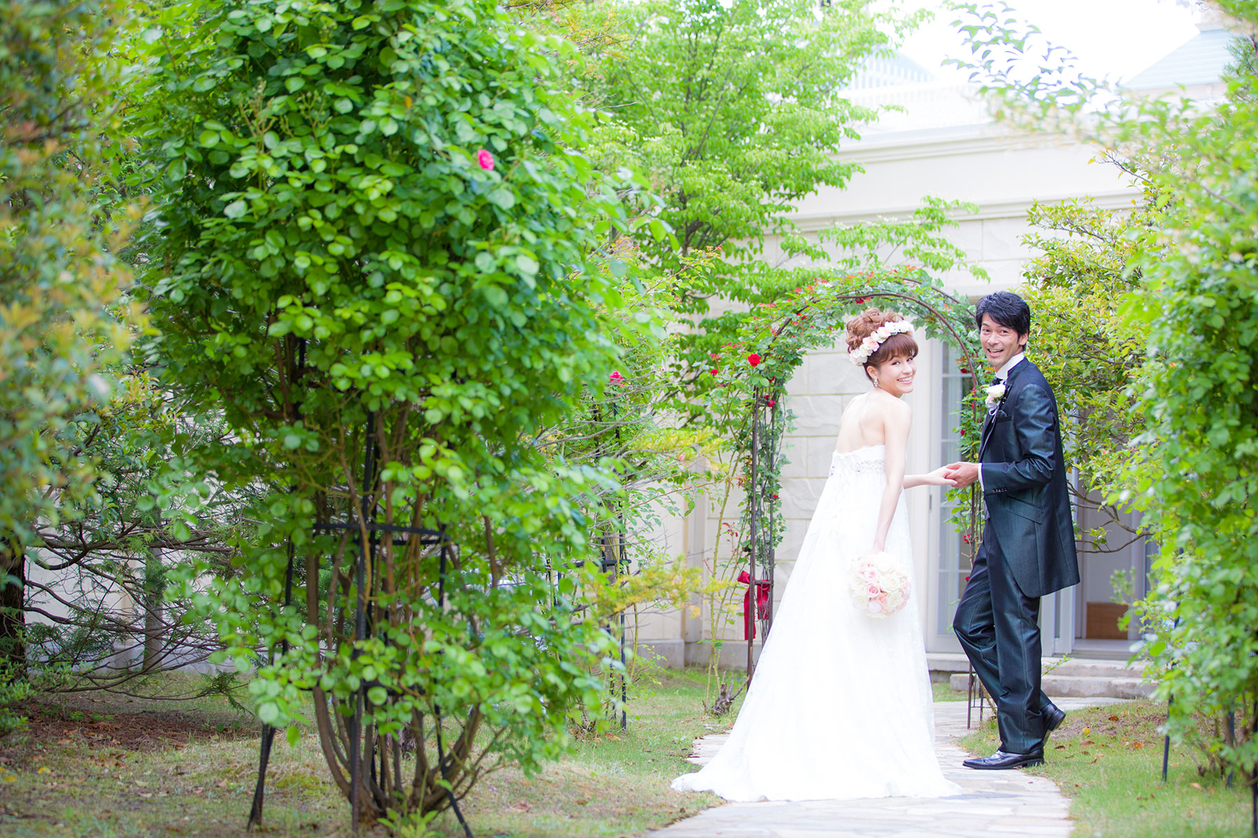 緑豊かなガーデンを歩く新郎新婦